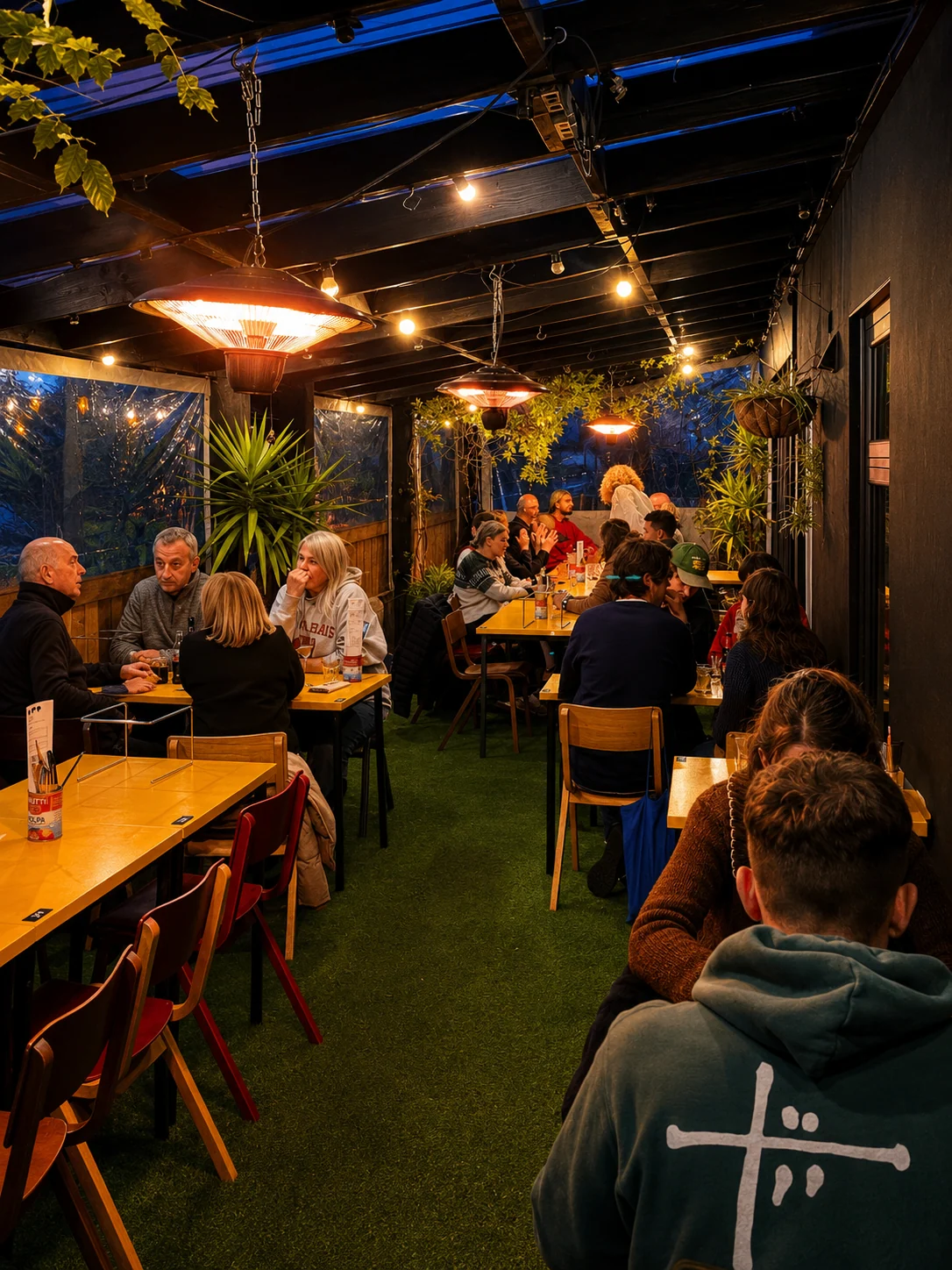 Guests dining beneath lights on the covered Lupa Pizza terrace